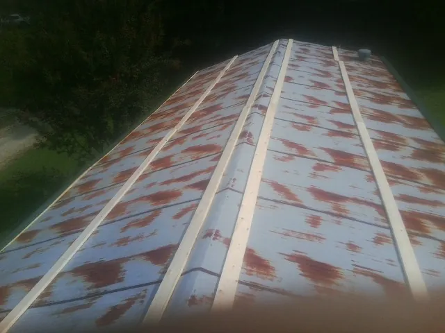 Rusted metal roof panels with new wood purlins before replacement — Storm Damage Roof Repair in Milledgeville by Roofing Brothers
