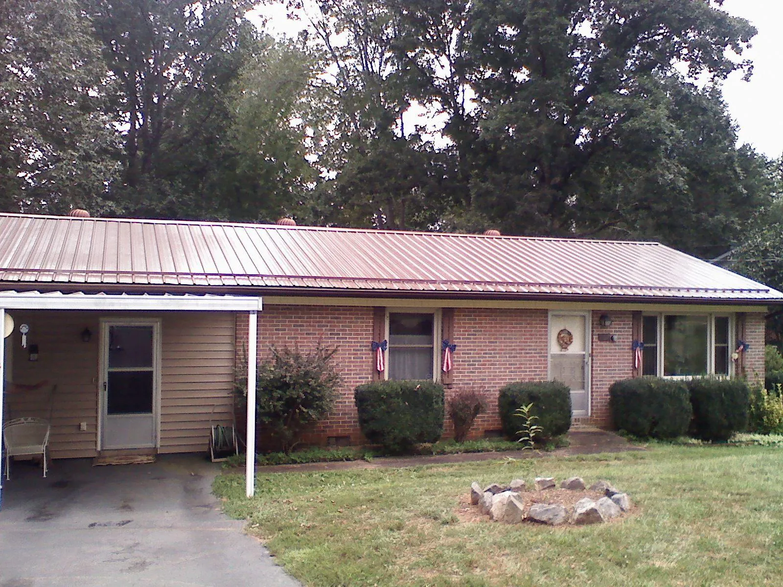 Bronze metal roof and carport on a brick ranch home — Roof Repair work by our crew in Milledgeville