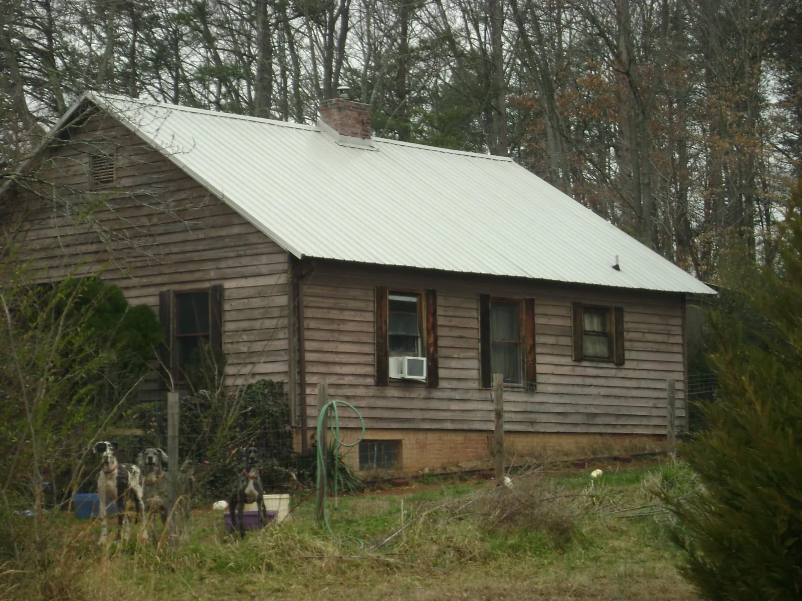 White metal roof on an old wood sided farmhouse, from a Metal Roof Installation job in Milledgeville